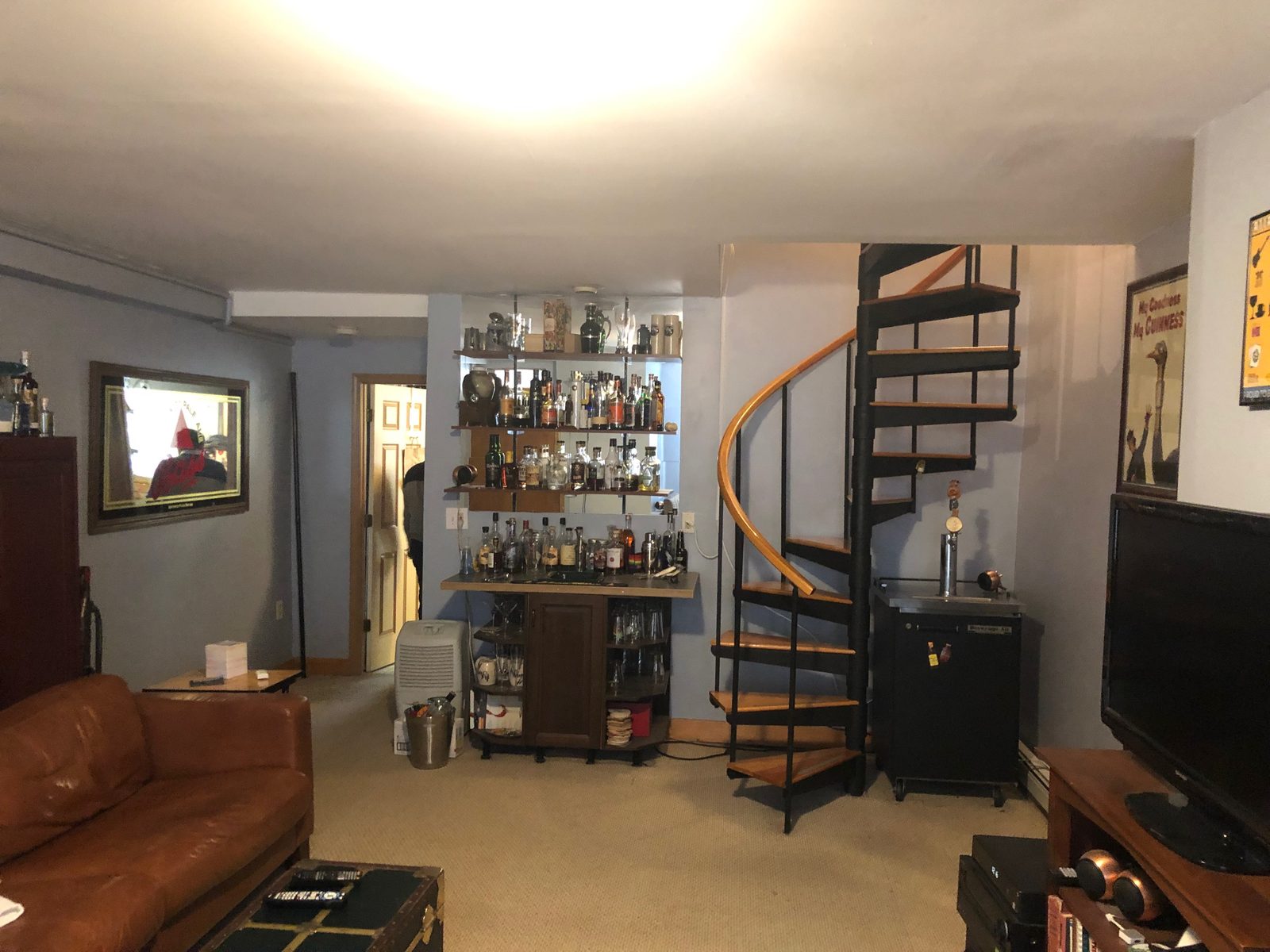 The bar and spiral stair before, filling the room with clutter