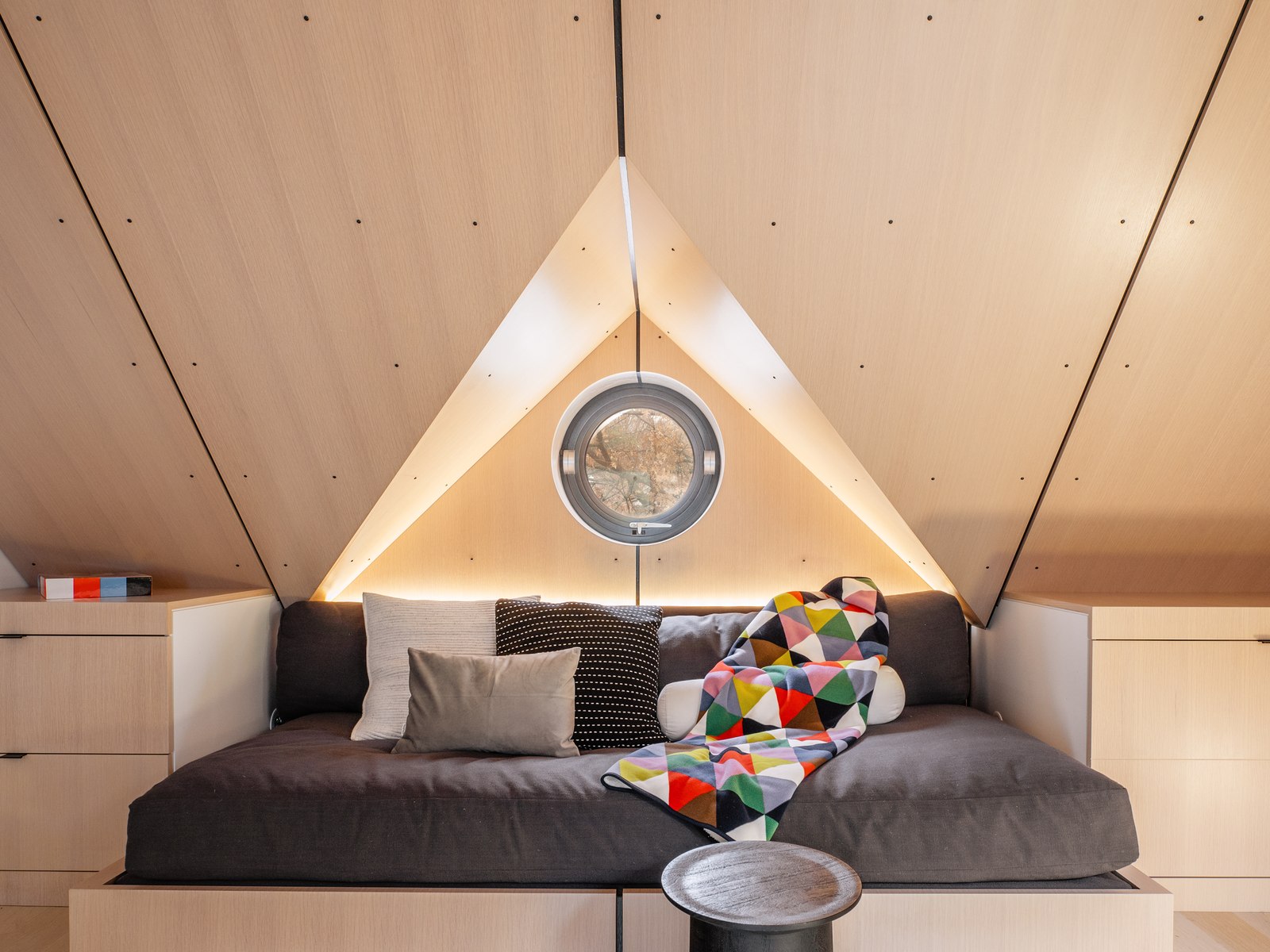 The same window, now an operable porthole above a daybed