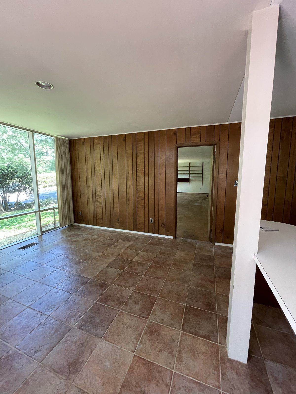 The kitchen area before, panelled walls and tile floor