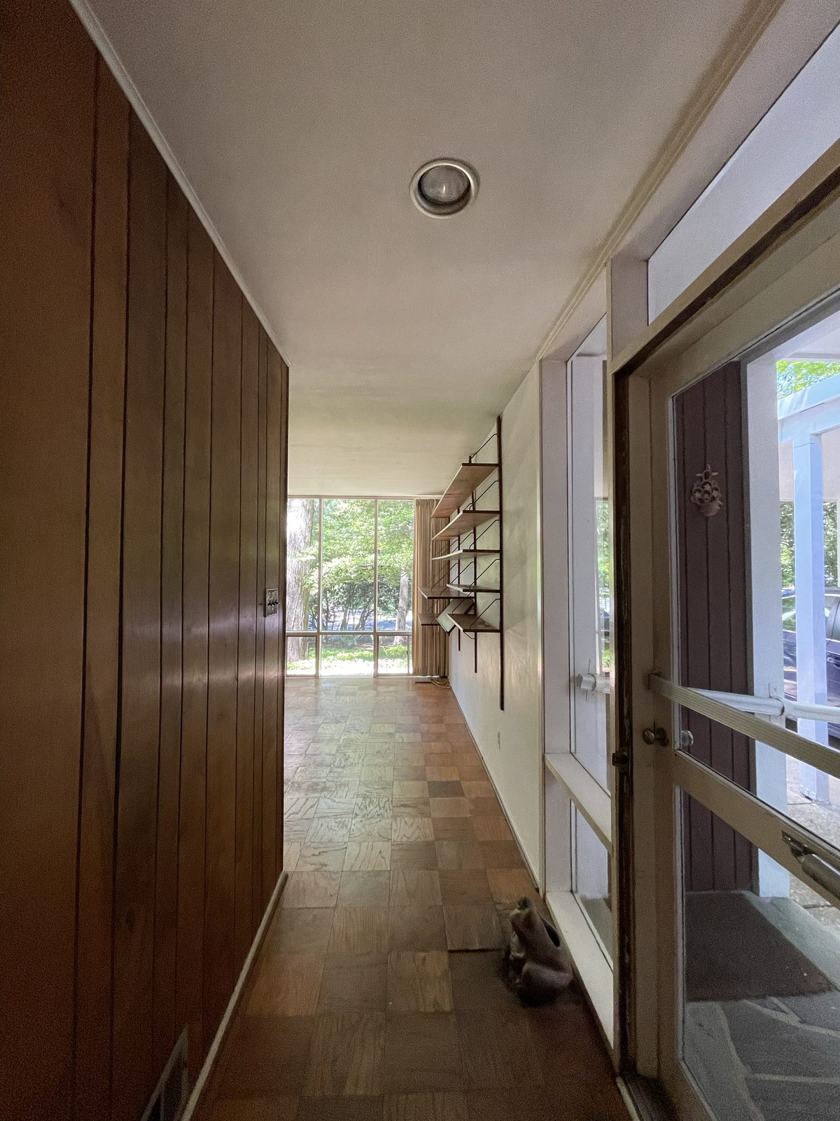 The entry hall before, panelling and wall-mounted shelving