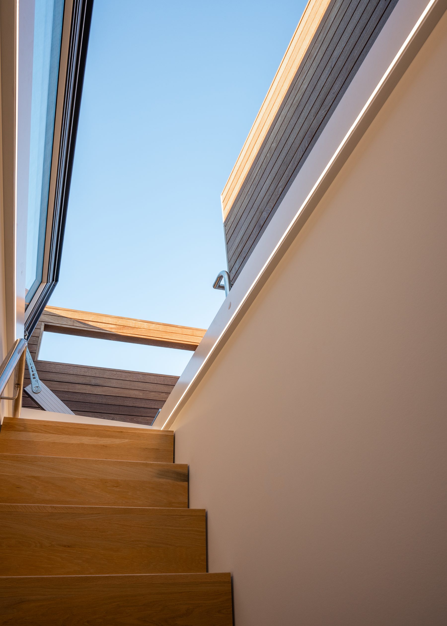 Motorized sky door open above the stair to the roof deck