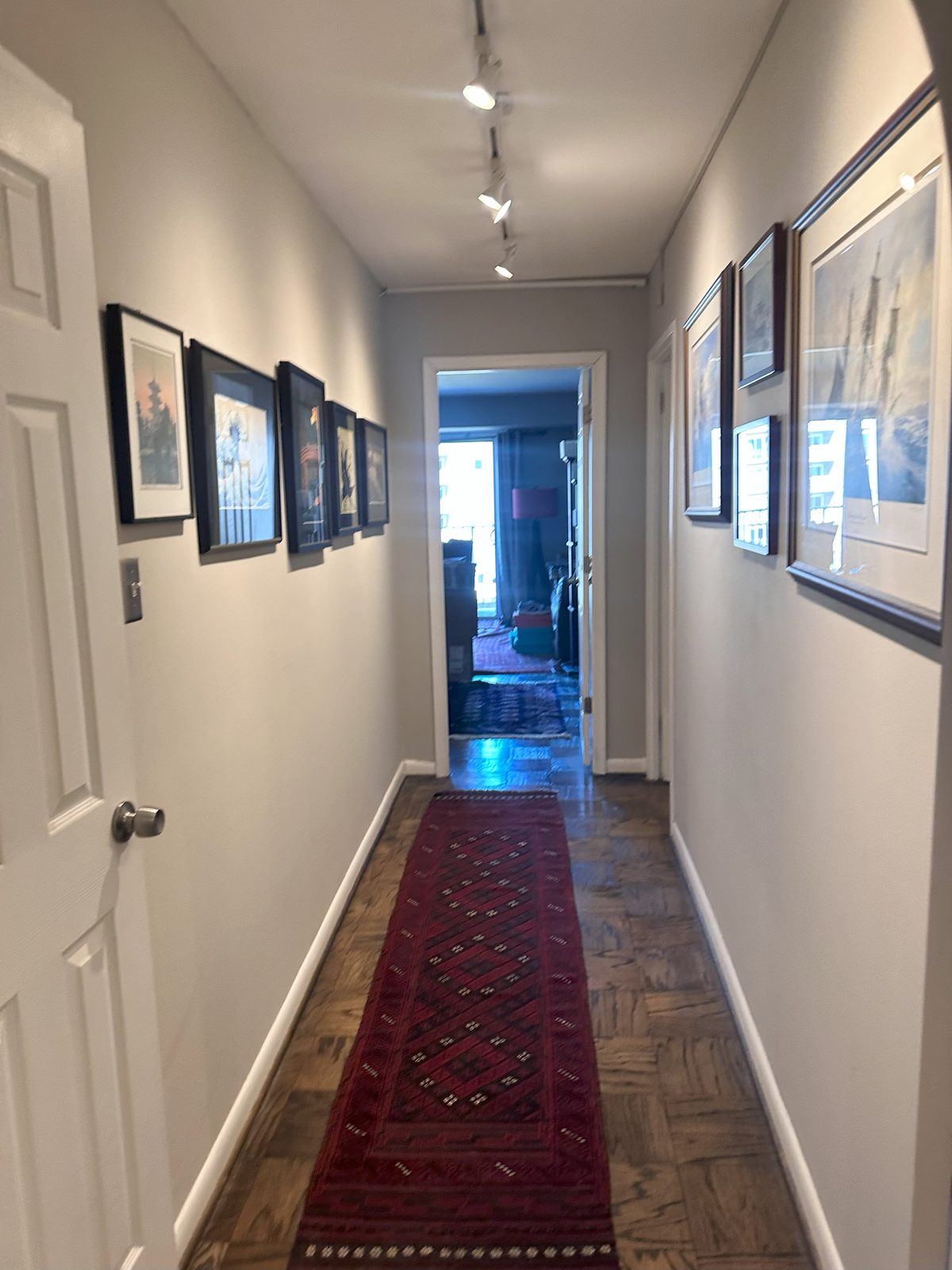 The hallway before, a gallery wall down a narrow parquet corridor