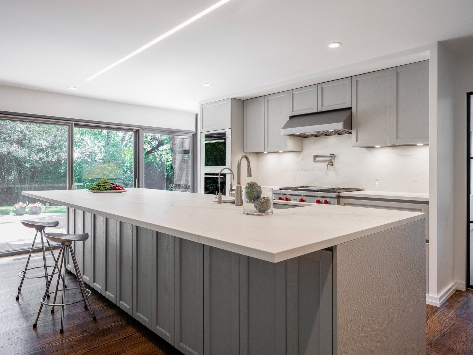 The kitchen now in that part of the floor, open along the glass to the yard